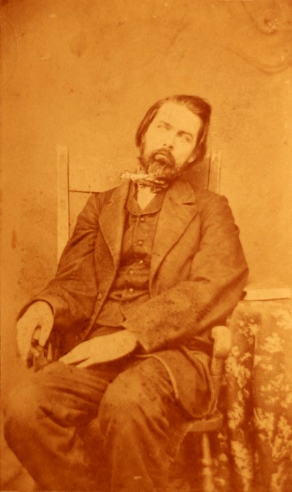 c1860 post-mortem photograph of a deceased man. The body is arranged so as to appear lifelike.[Source: Public Domain]
